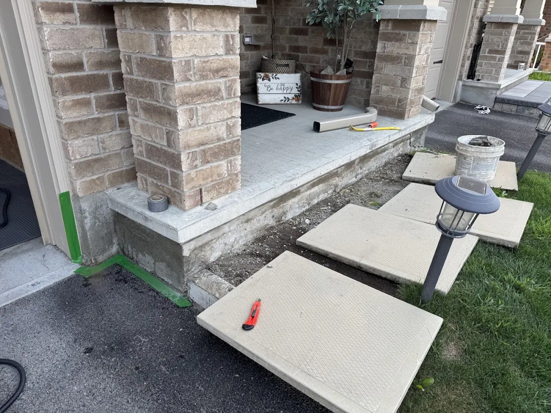 New stone steps and pillars being set at a front entrance